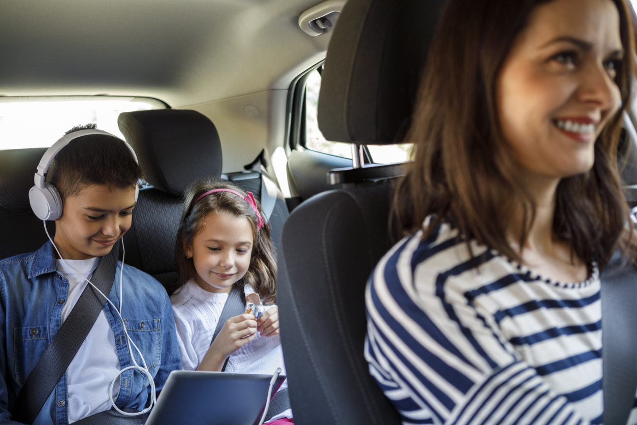 Fratelli in auto guardano insieme lo smartphone