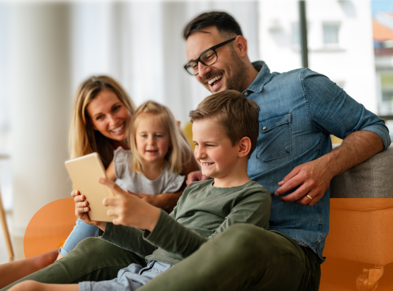 Famiglia guarda insieme un tablet sul divano