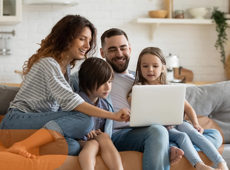 Famiglia guarda insieme il computer sul divano