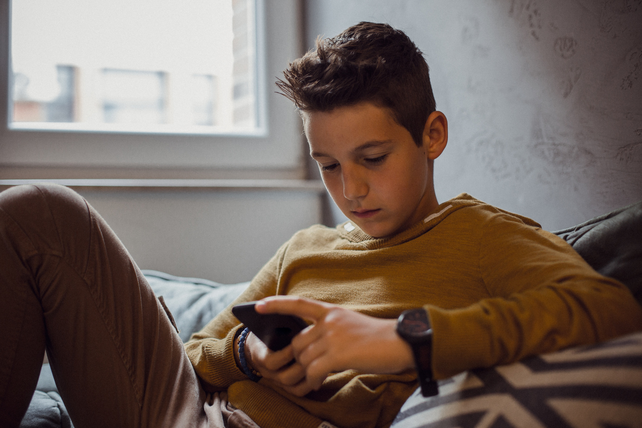 Adolescente guarda il cellulare nella sua camera da letto