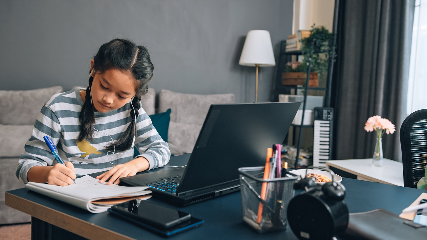 Una adolescente scrive una storia davanti al laptop