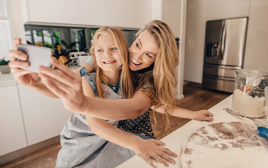 Una donna e una ragazzina fotografano un dolce con dispositivo digitale