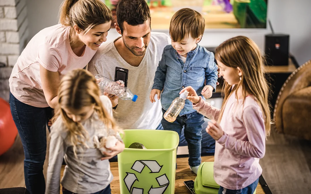 Una famiglia guarda un bidone della raccolta differenziata con dispositivo digitale