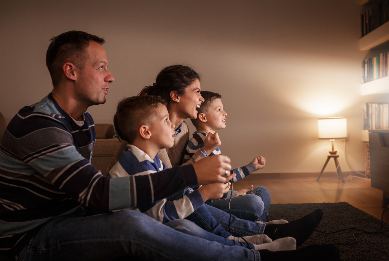 Famiglia con bambini piccoli che gioca a videogioco