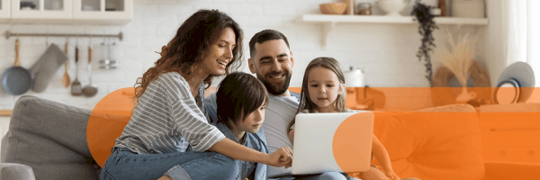 Famiglia guarda insieme il computer sul divano
