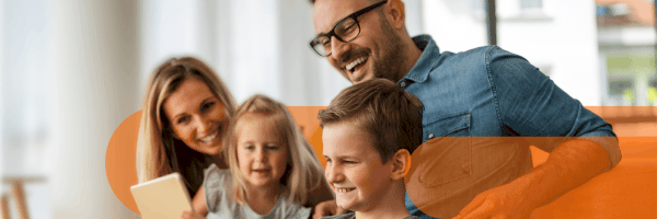 Famiglia guarda insieme un tablet sul divano