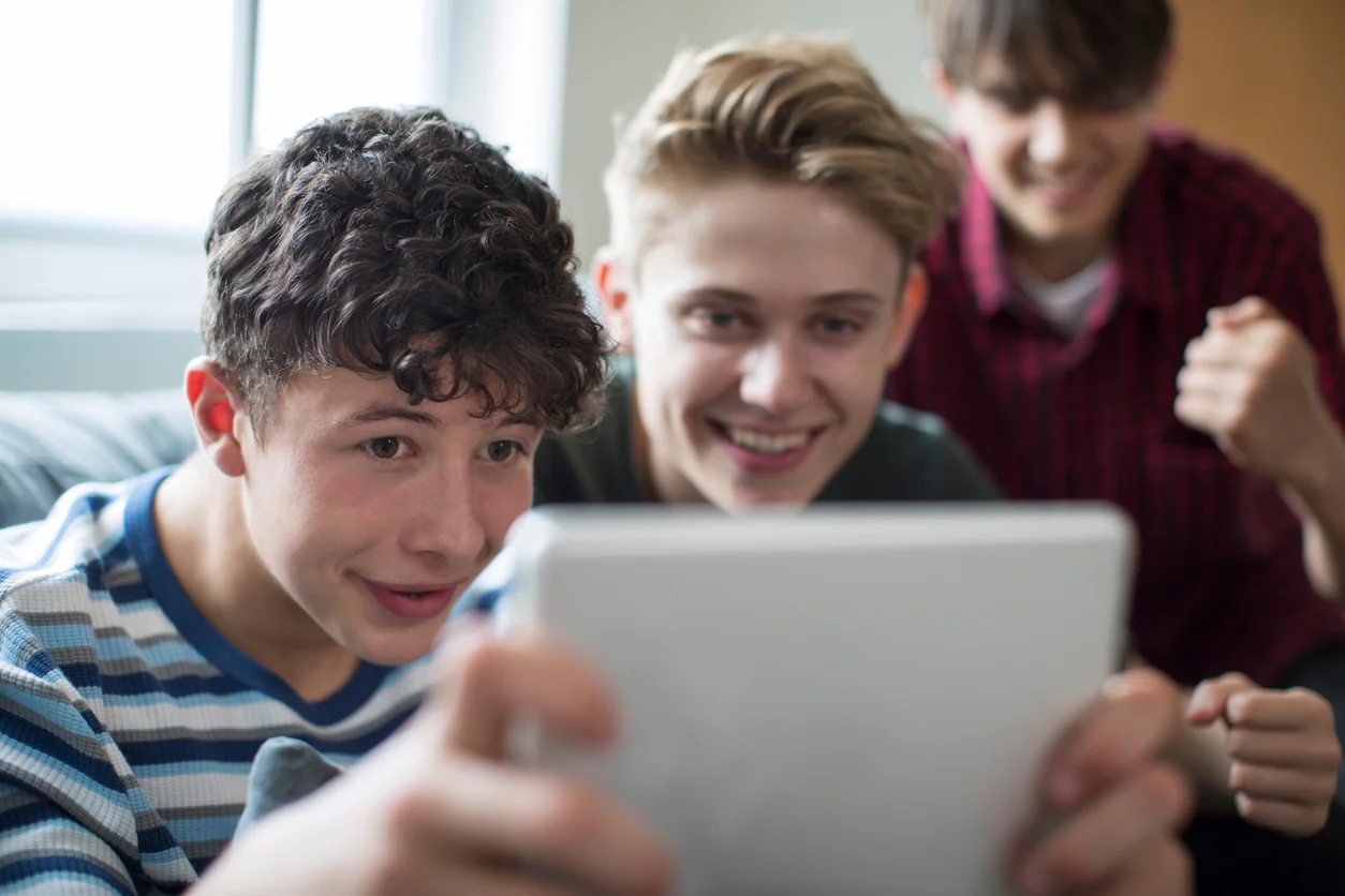 Un gruppo di giovani seduti su un divano con dispositivo digitale