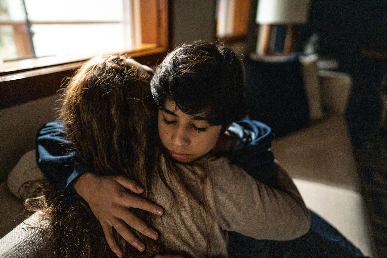 Madre che abbraccia e consola il figlio triste a casa