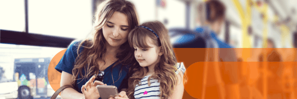 Madre e figlia guardano uno smartphone sull'autobus