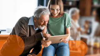 Nonno e nipotina guardano insieme un tablet