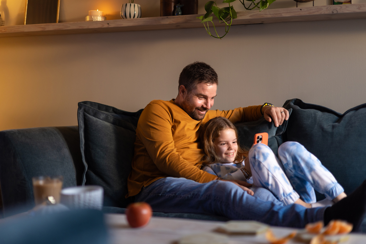 Papà e figlia passano del tempo divertente insieme con il cellulare