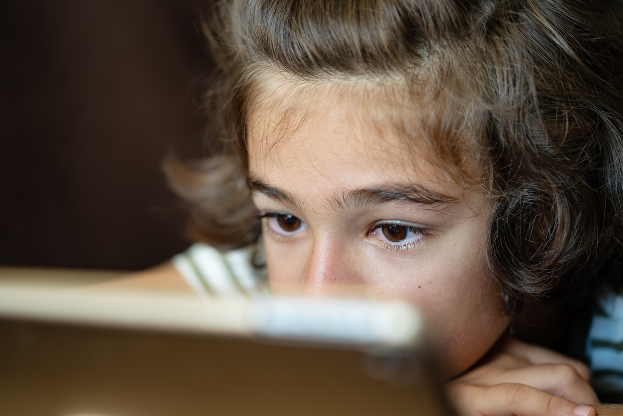 Primo piano di un bambino che guarda un tablet