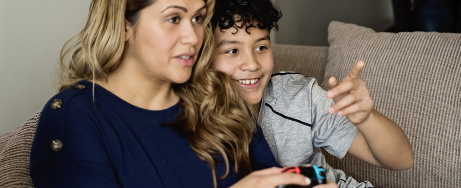 Madre e figlio giocano insieme ai videogame condividendo tempo di qualità