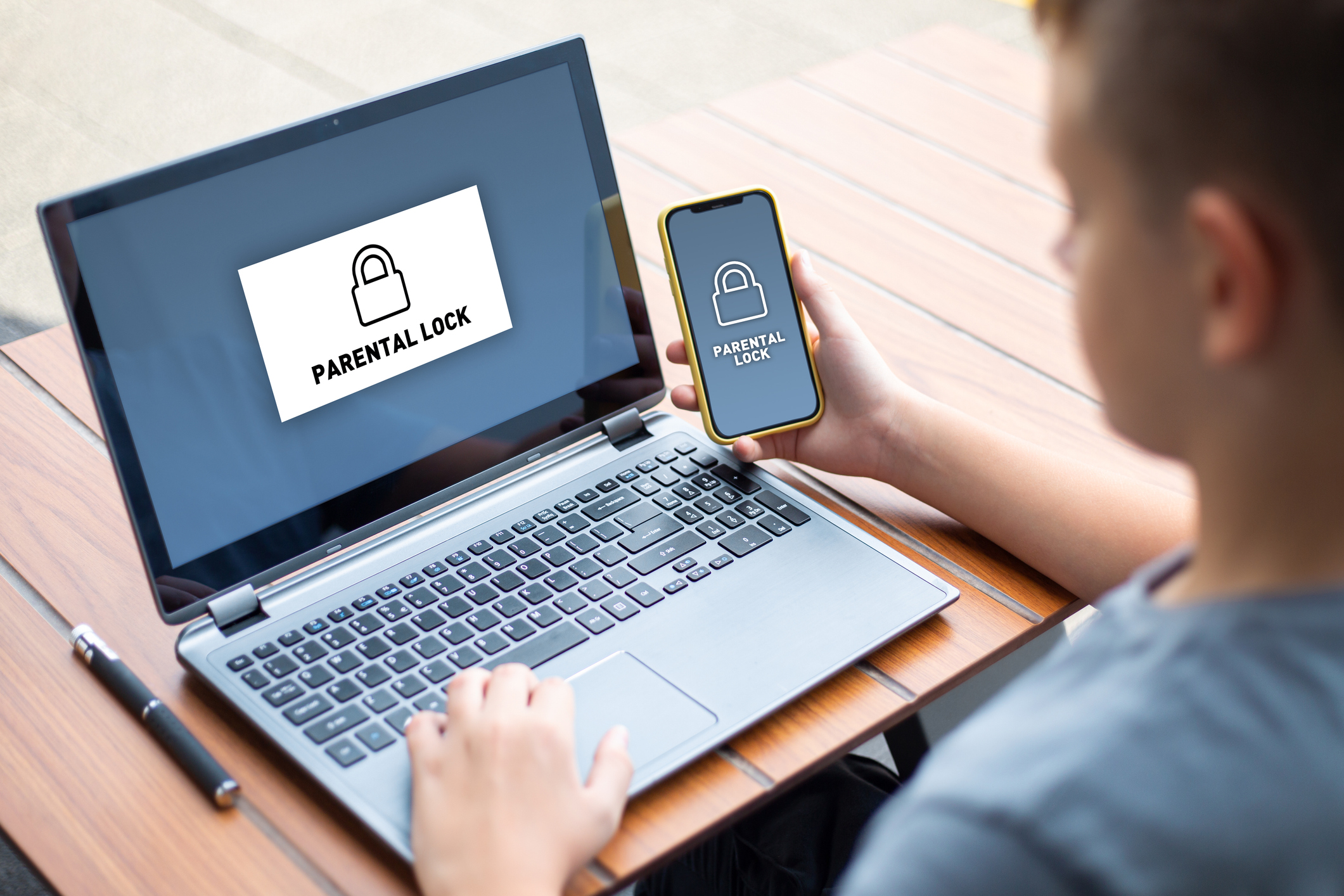 Adolescente con iPhone e laptop. Schermata con concetto di blocco parentale.