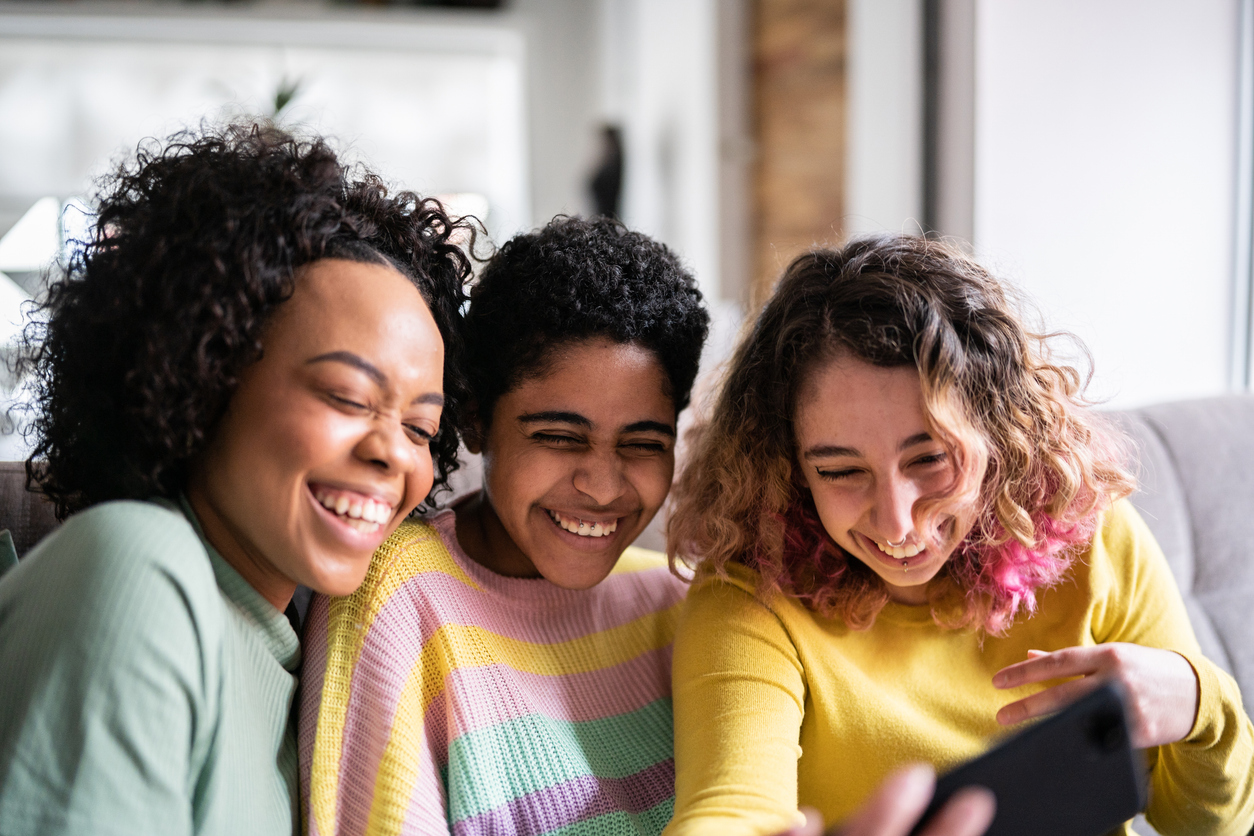 Amiche che guardano uno smartphone e ridono
