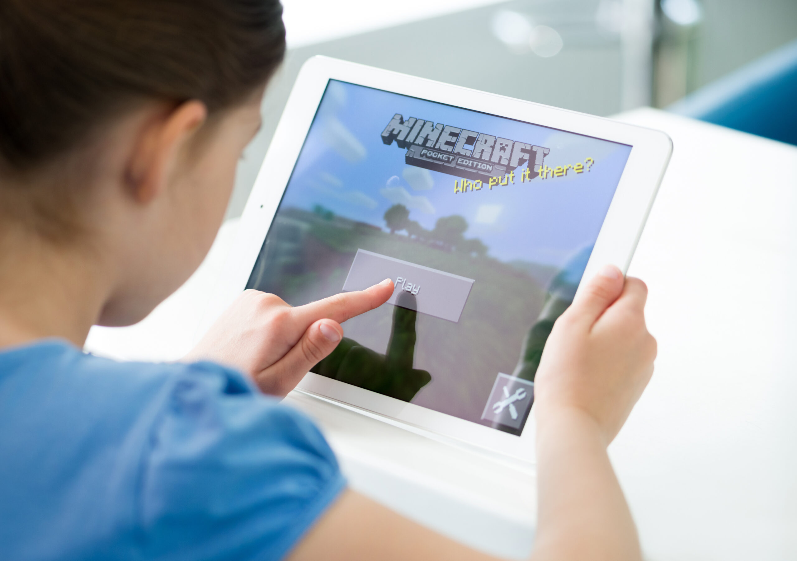 Una bambina che gioca a minecraft su tablet