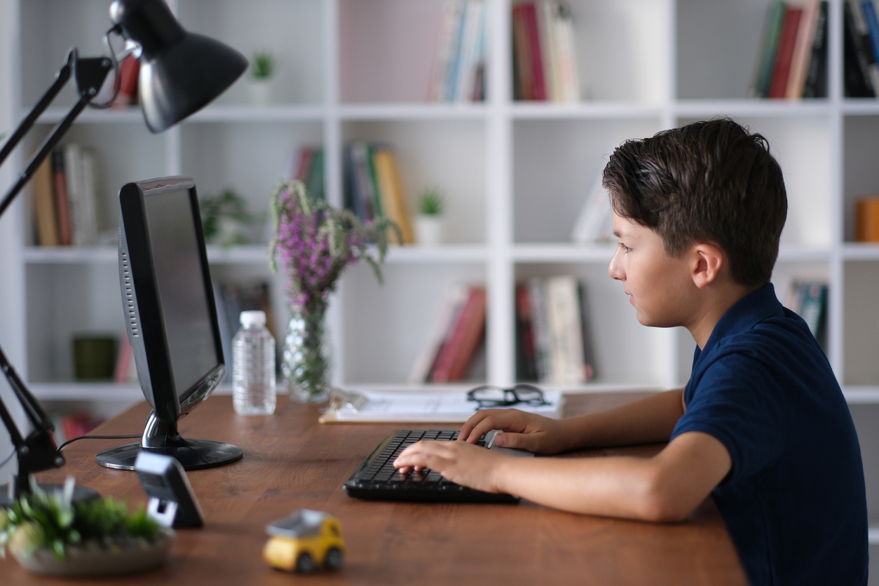 Bambino digita sulla tastiera di un computer