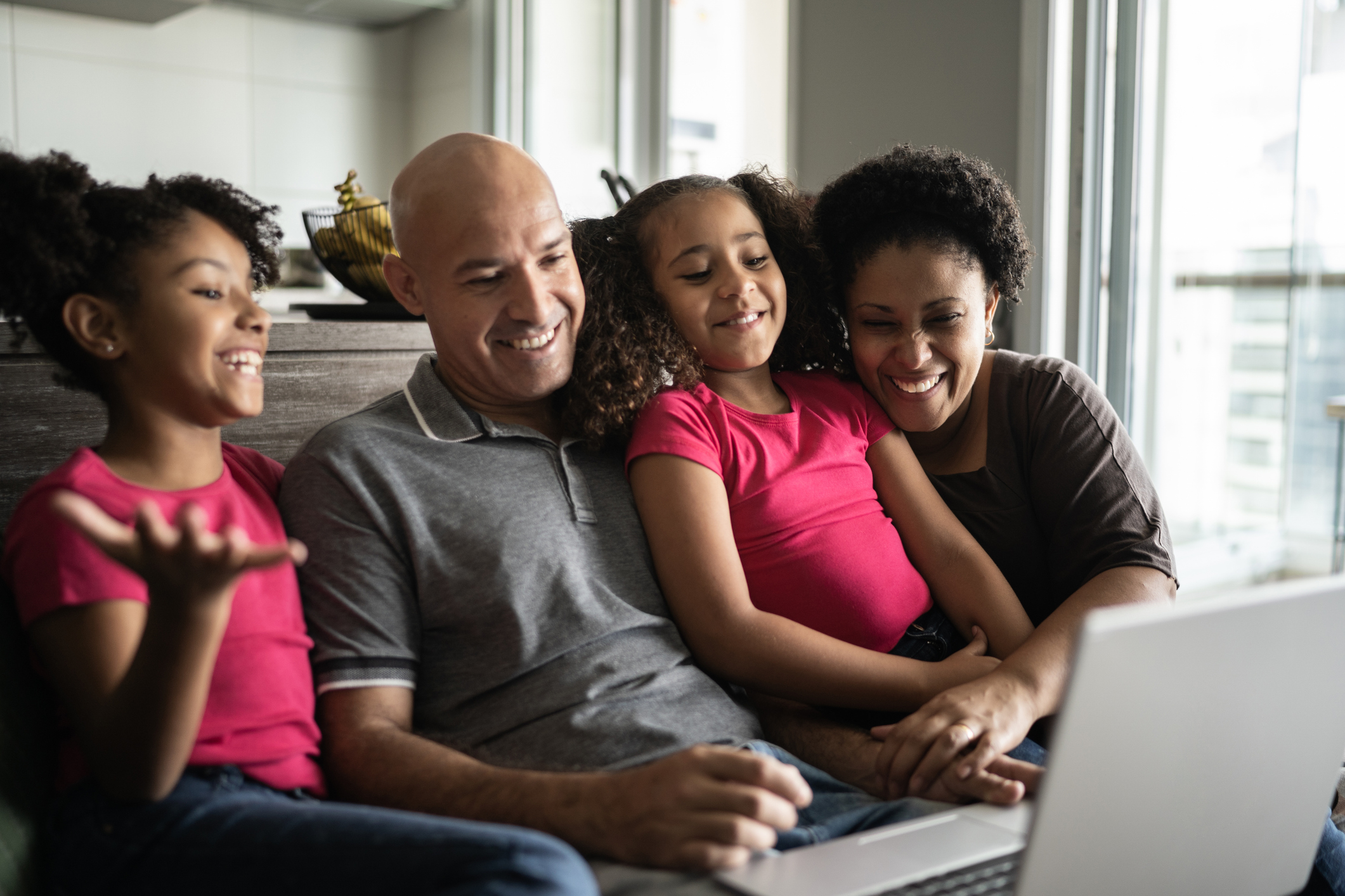 Una famiglia seduta sul divano con un laptop