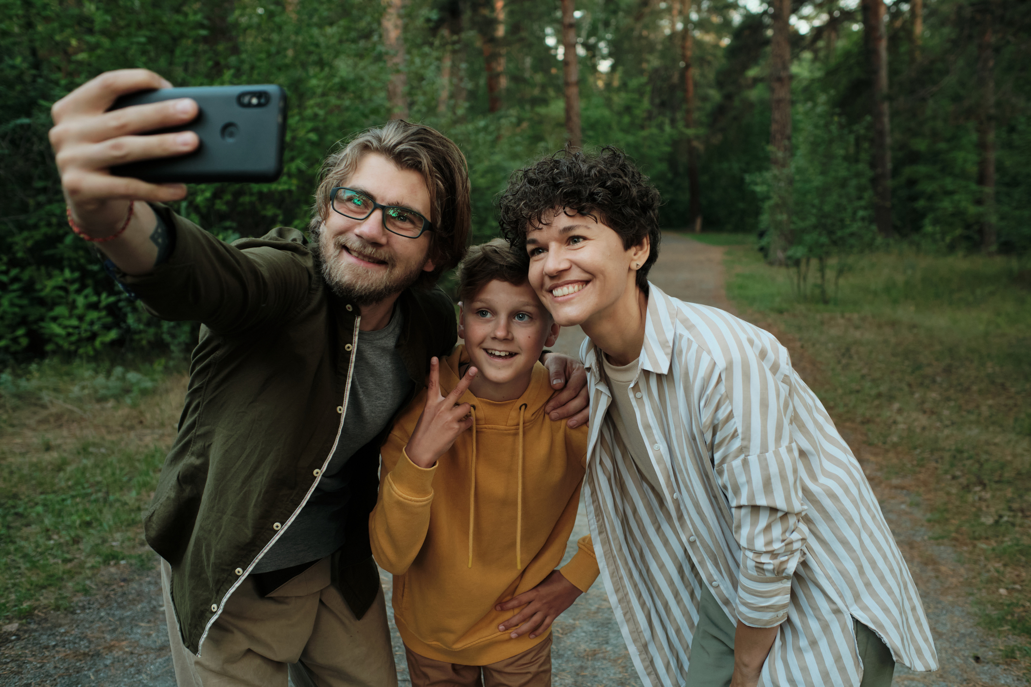 Famiglia formata da giovani genitori felici e figlio che fanno un selfie durante un viaggio