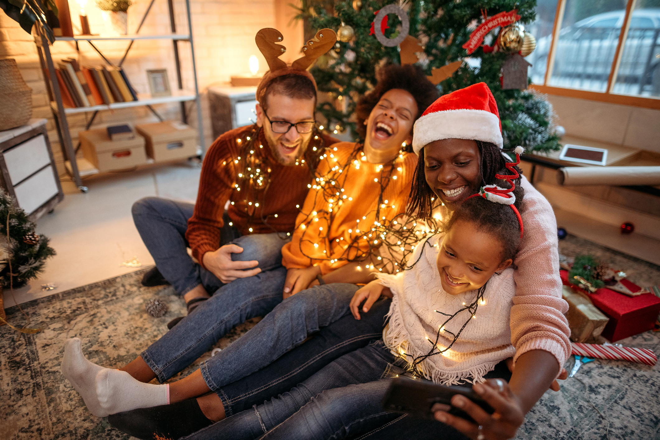 Una famiglia a natale si diverte guardando uno smartphone