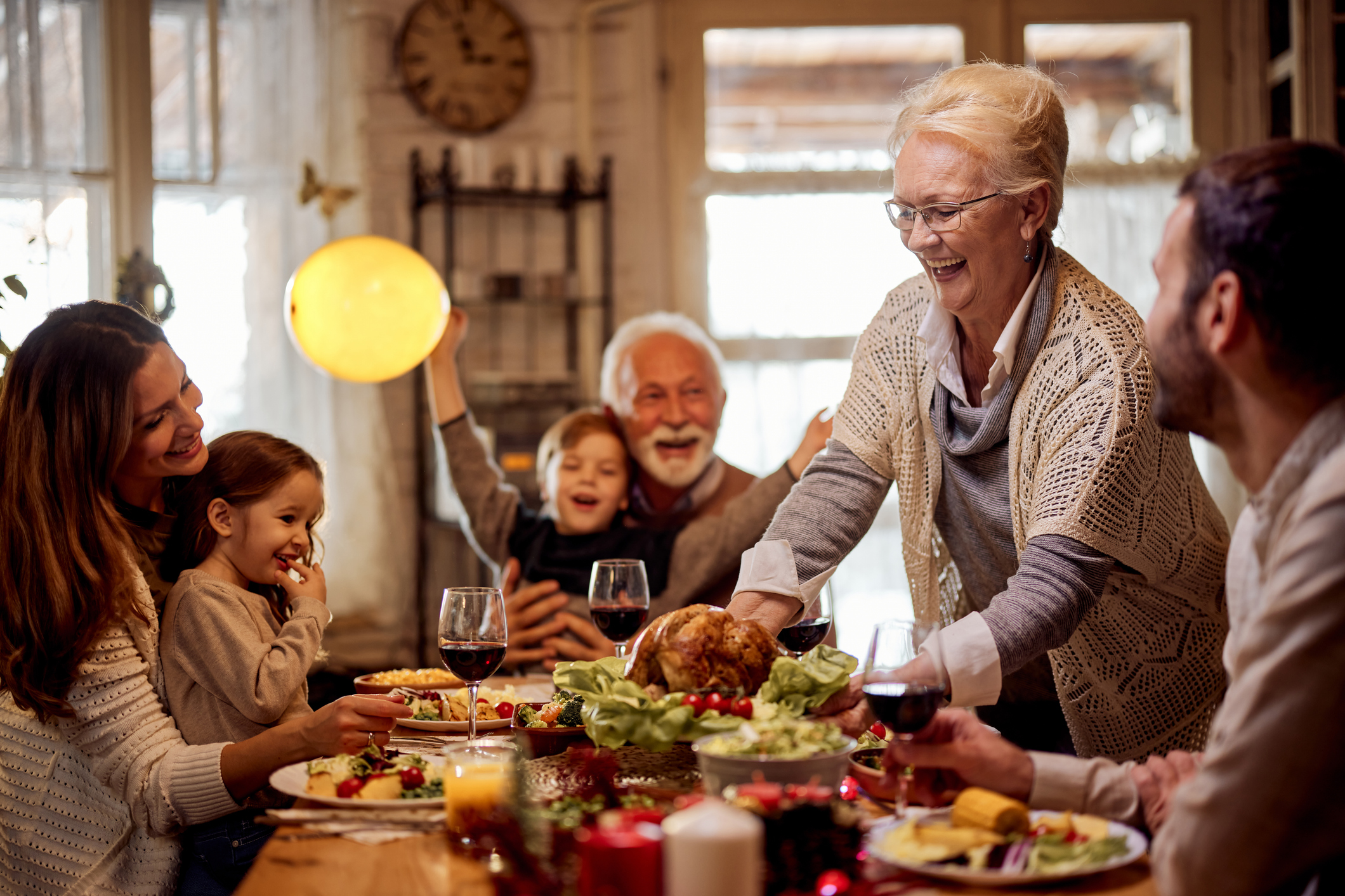 Una famiglia numerosa riunita a mangiare attorno alla tavola