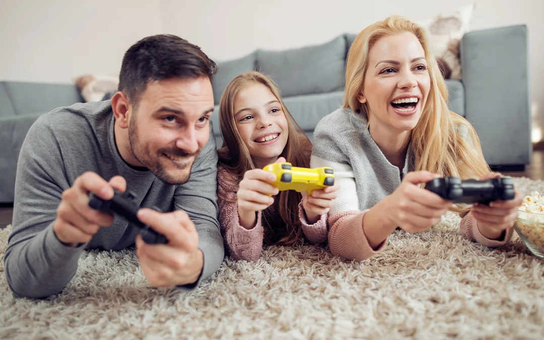Una famiglia gioca a videogiochi per terra con dispositivo digitale
