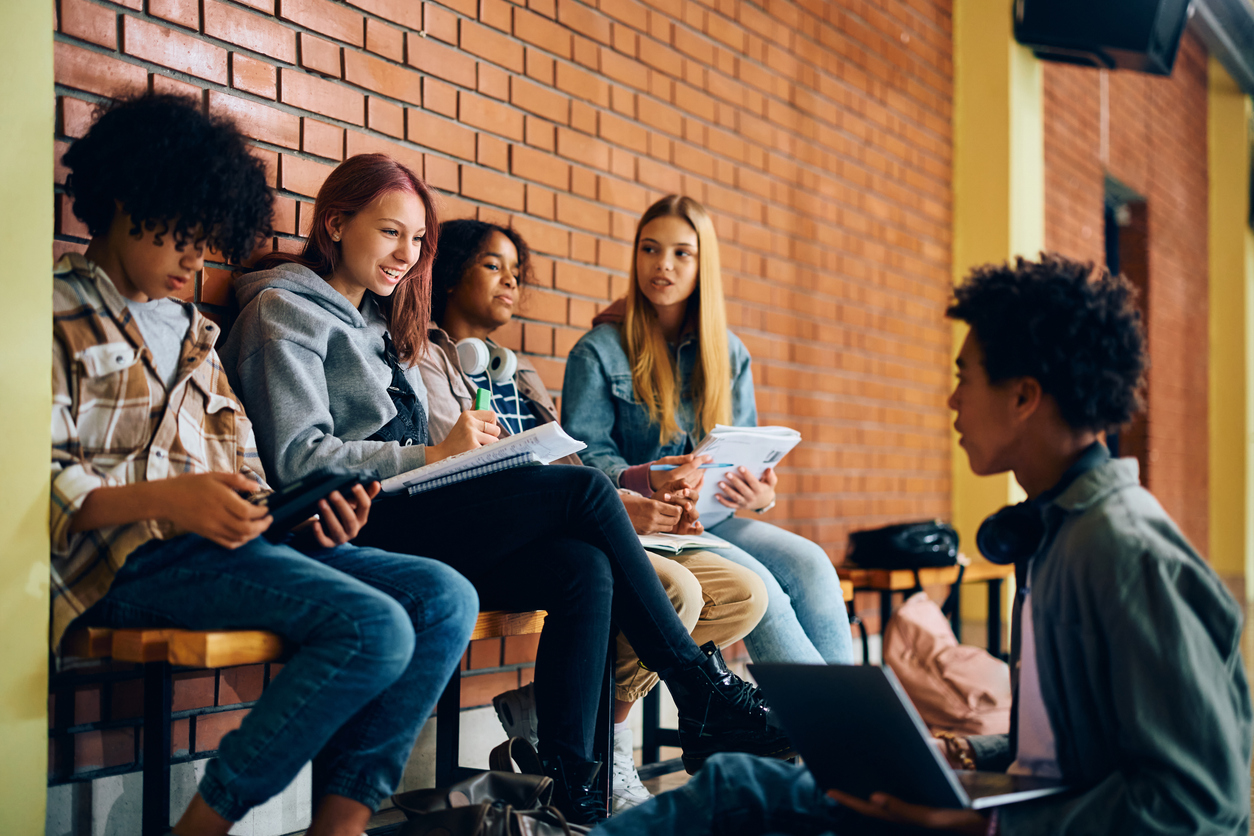 Un gruppo di ragazzi studia e utilizza dispositivi digitali