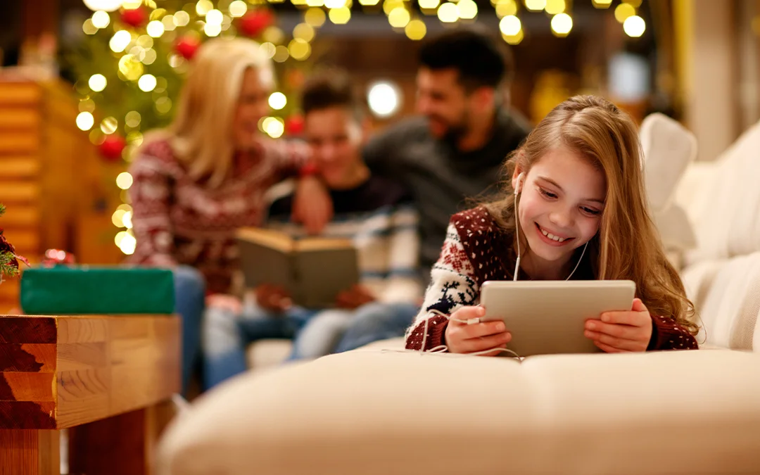 Una ragazzina sorride mentre usa un tablet