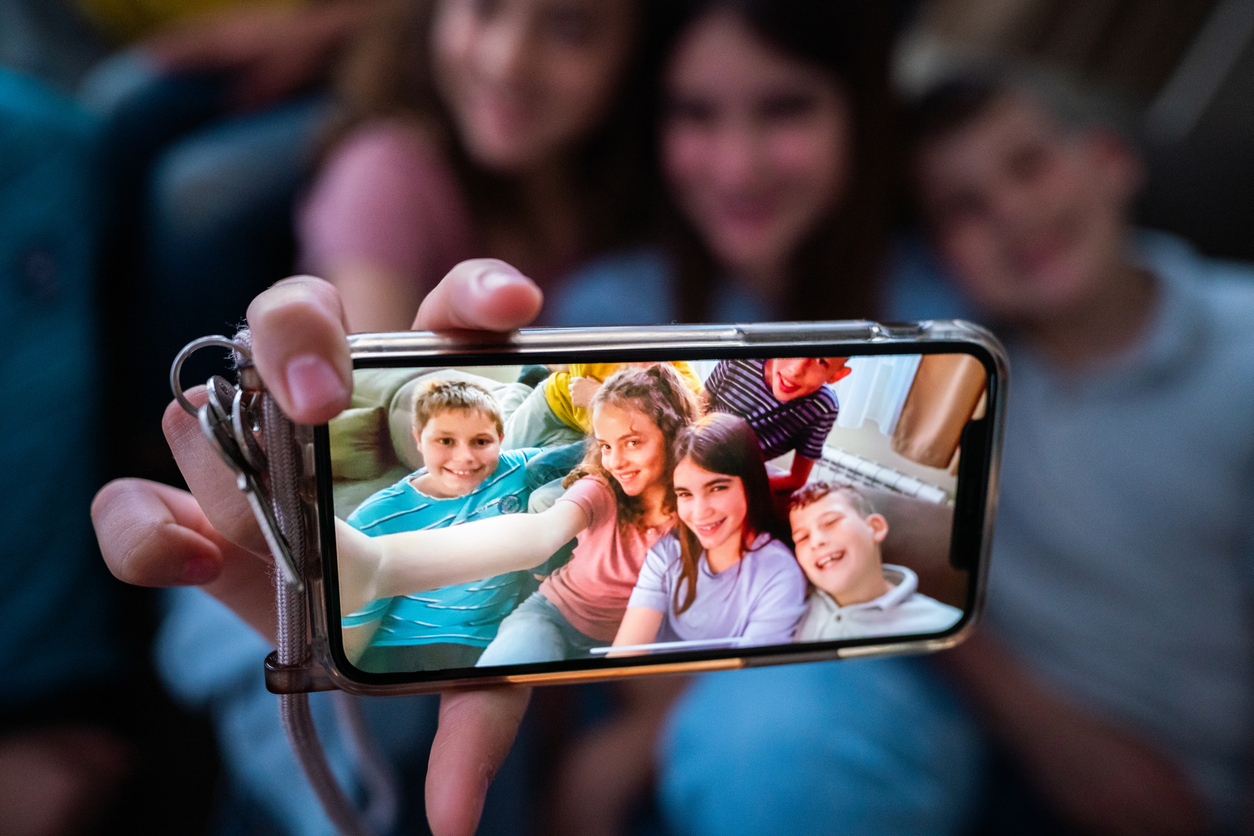 Gruppo di ragazzini si fanno selfie con gli smartphone