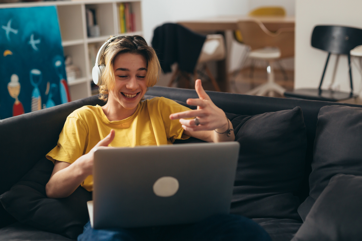 Un ragazzo gioca e ride guardando il computer