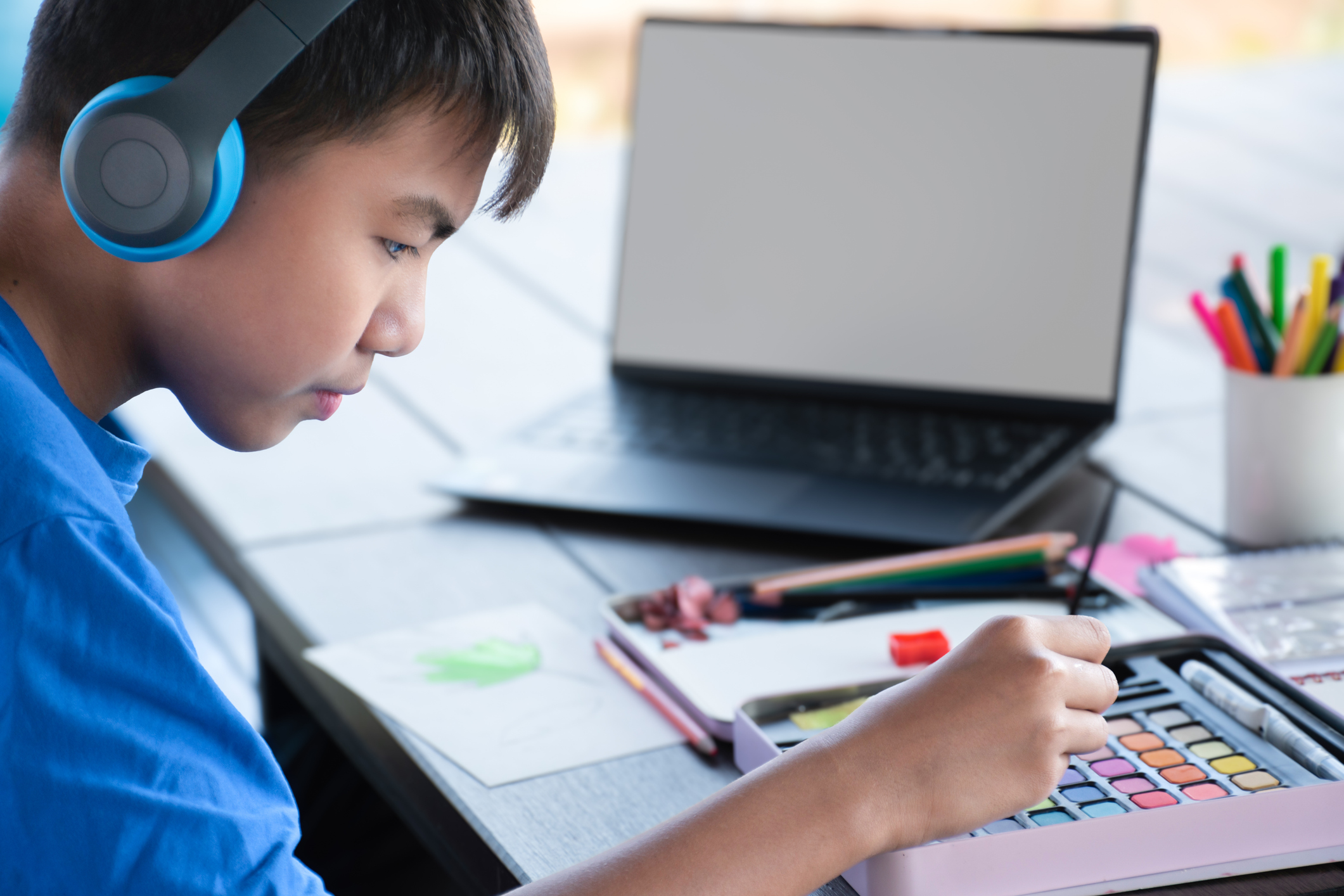 Ragazzino che disegna e utilizza un laptop